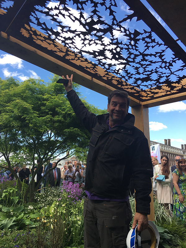 DIY SOS The Big Build's Nick Knowles pointing at beautiful garden pergola on a roof space at the Great Ormond Street Hospital cut by Nigel Ferguson Fabrications on the Swift-Cut Pro CNC plasma cutting machine