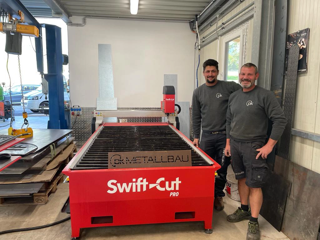 Owners of Metallbau standing next to their Swift-Cut Pro plasm metal cutting machine