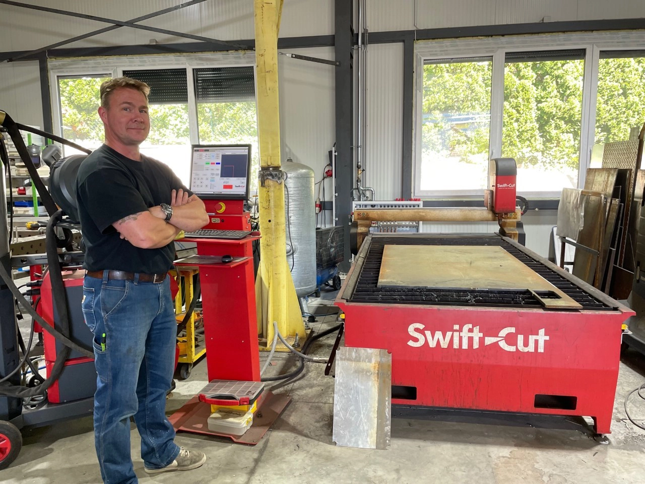 Schlosserbub owner standing next to his Swift-Cut Pro CNC Plasma Cutting Table