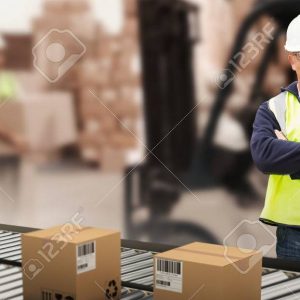 Composite image of worker wearing hard hat in warehouse Worker wearing hard hat in warehouse against warehouse worker loading up pallet